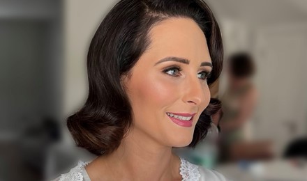 bride smiling to the right just after getting her bridal hair and make done.