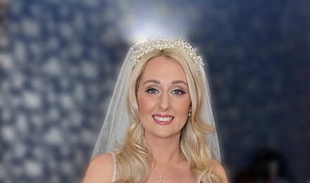 Bride in her wedding dress holding her flowers after her make up application